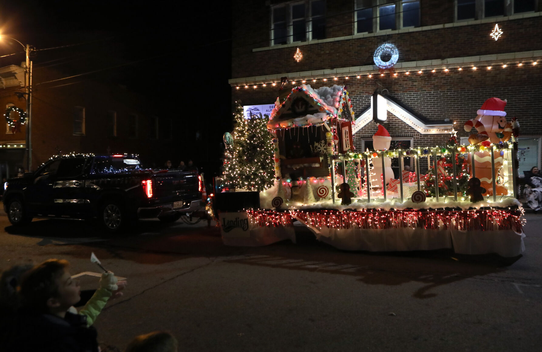 A gingerbread house float drives by